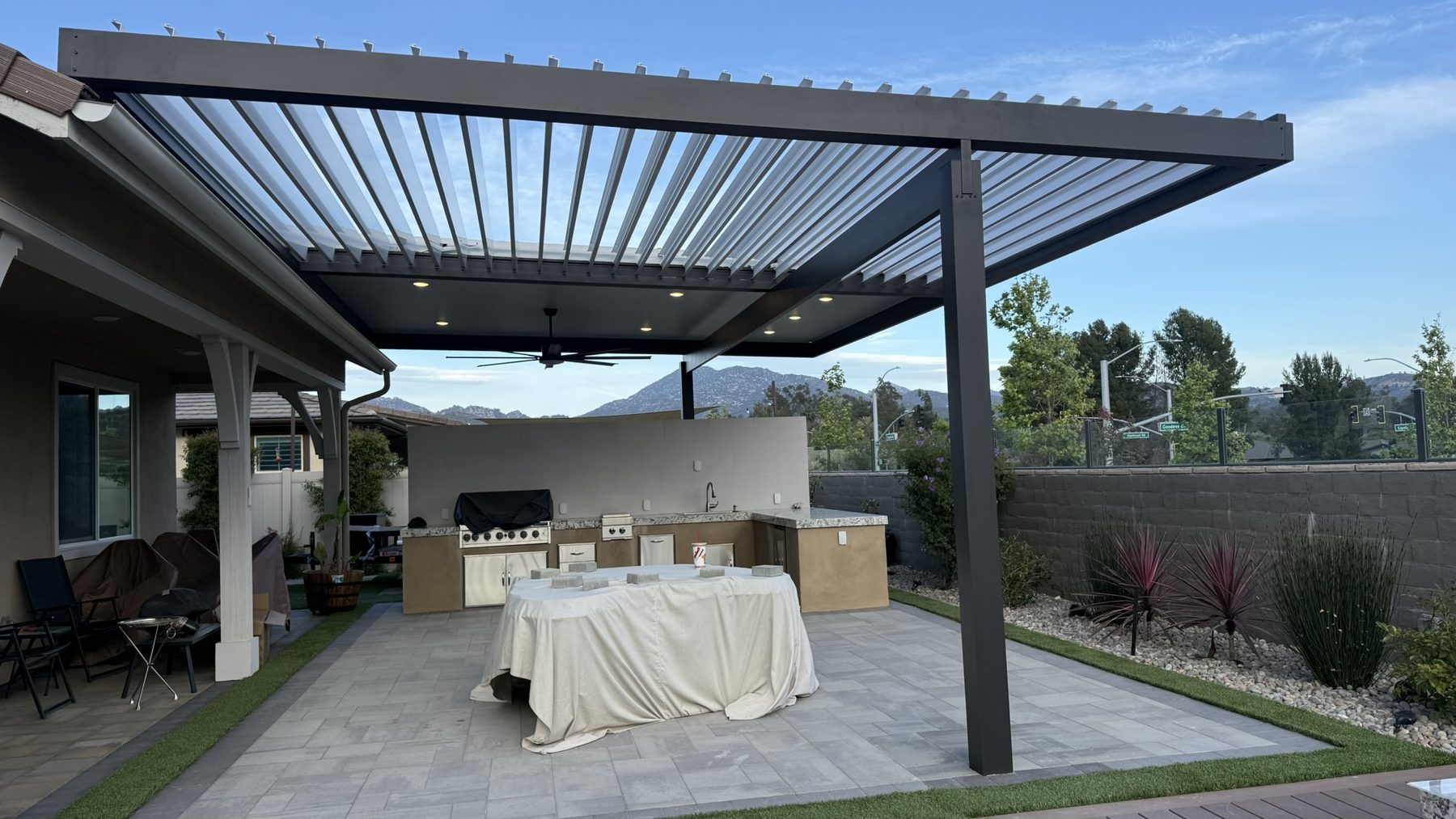 Louvered patio cover above an outdoor kitchen